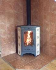 Недорогая печь-камин Бавария угловая с плитой незабудка Амазонка бай фото в интерьере в Новополоцке