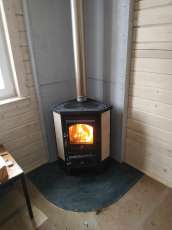 Недорогая печь-камин со стеклом Бавария угловая с плитой фото в интерьере в Новополоцке